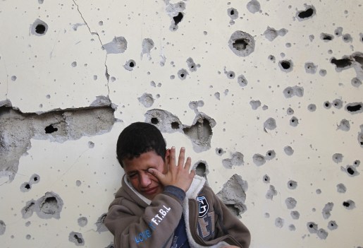Palestinian boy Fares Sadallah, 11, cries as he sits outside his home which was damaged following an Israeli air strike in Beit Lahia, northern Gaza Strip, on November 16, 2012. 
