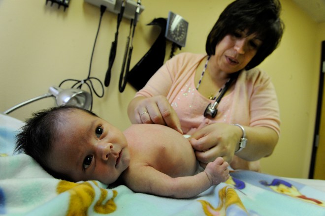 Medical Director Elisa Melendez examines Maximo Chavez, during his two week checkup at Clinica Tepeyac in Denver, CO, Thursday, March 22, 2012. His mother, Lilian Mendoza, says her family does not have insurance but hopes Maximo will qualify for Medicaid