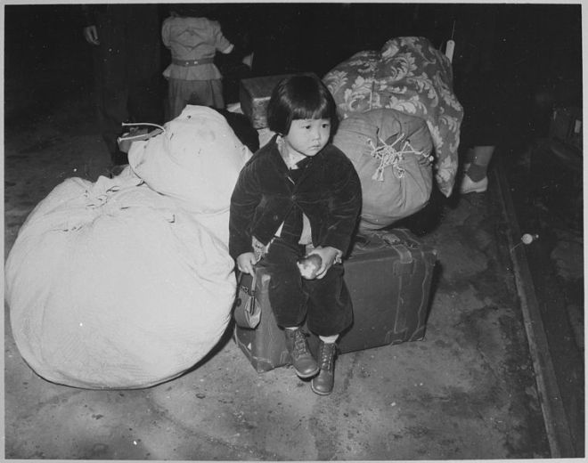 760px-A_young_evacuee_of_Japanese_ancestry_waits_with_the_family_baggage_before_leaving_by_bus_for_an_assembly_center..._-_NARA_-_539959